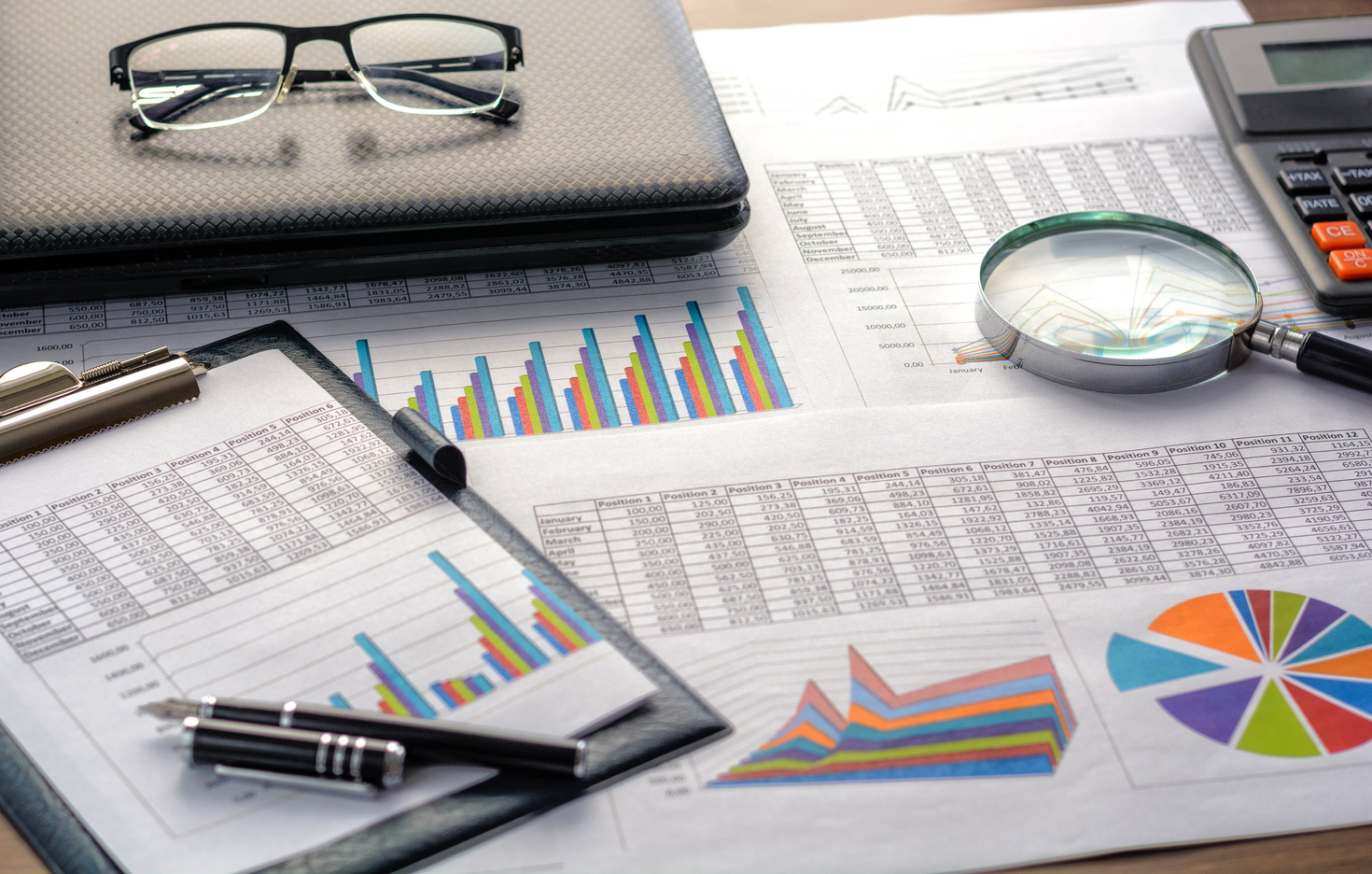 Financial documents – graphics, statistics, drawings, keyboard, laptop, magnifying glass in the office. Business, science, long hours of work. Curso en Rastreo Epidemiológico en COVID 19