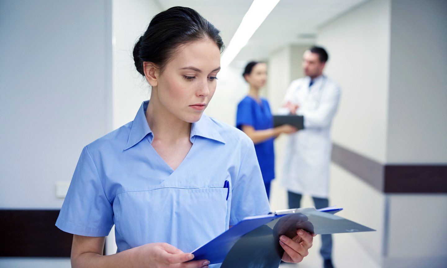 female doctor or nurse with clipboard at hospital Sistemas de Evaluación - Curso en Inmunización frente al SARS-COV2