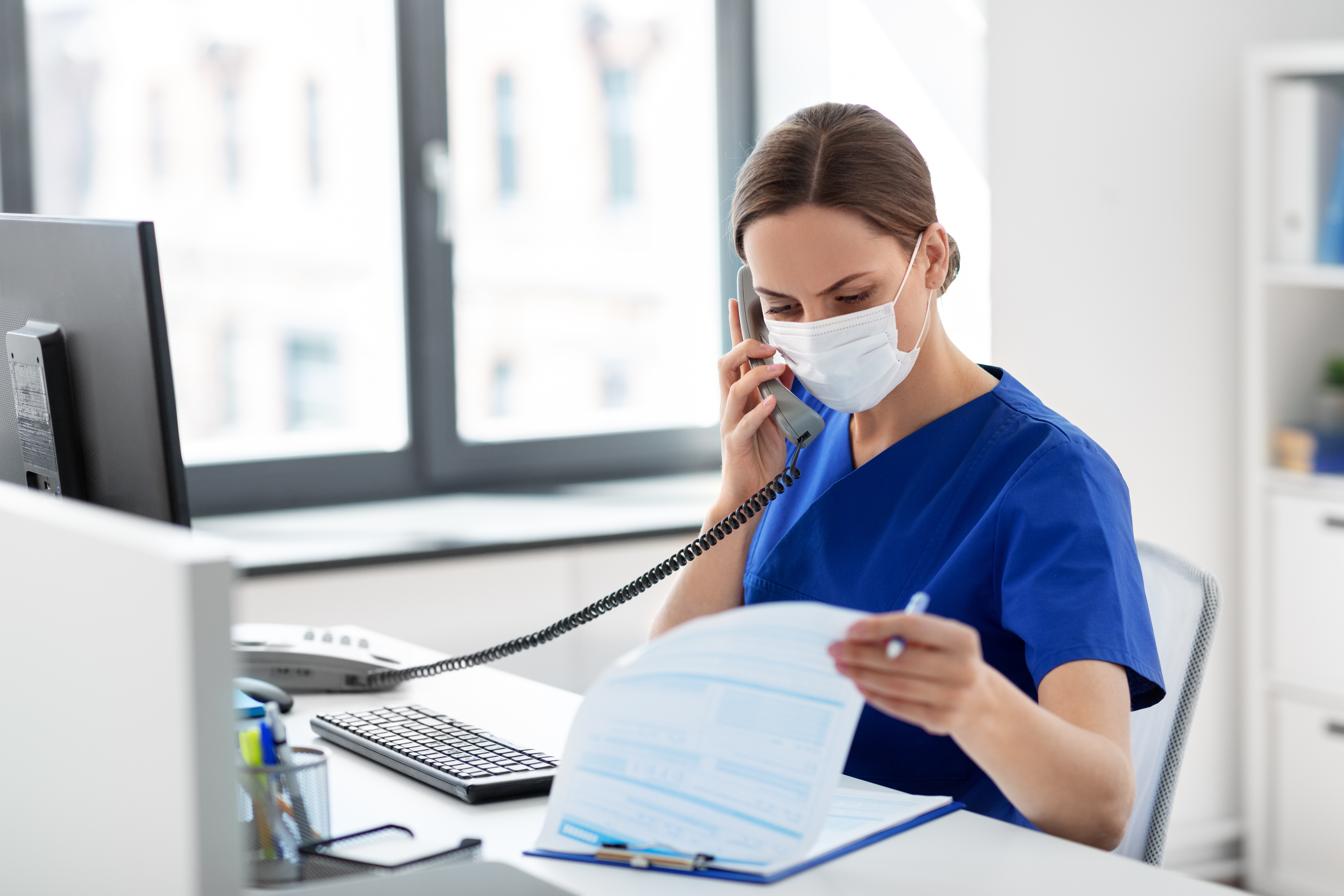 doctor with computer calling on phone at hospital Sistemas de Evaluación - Curso en Inmunización frente al SARS-COV2