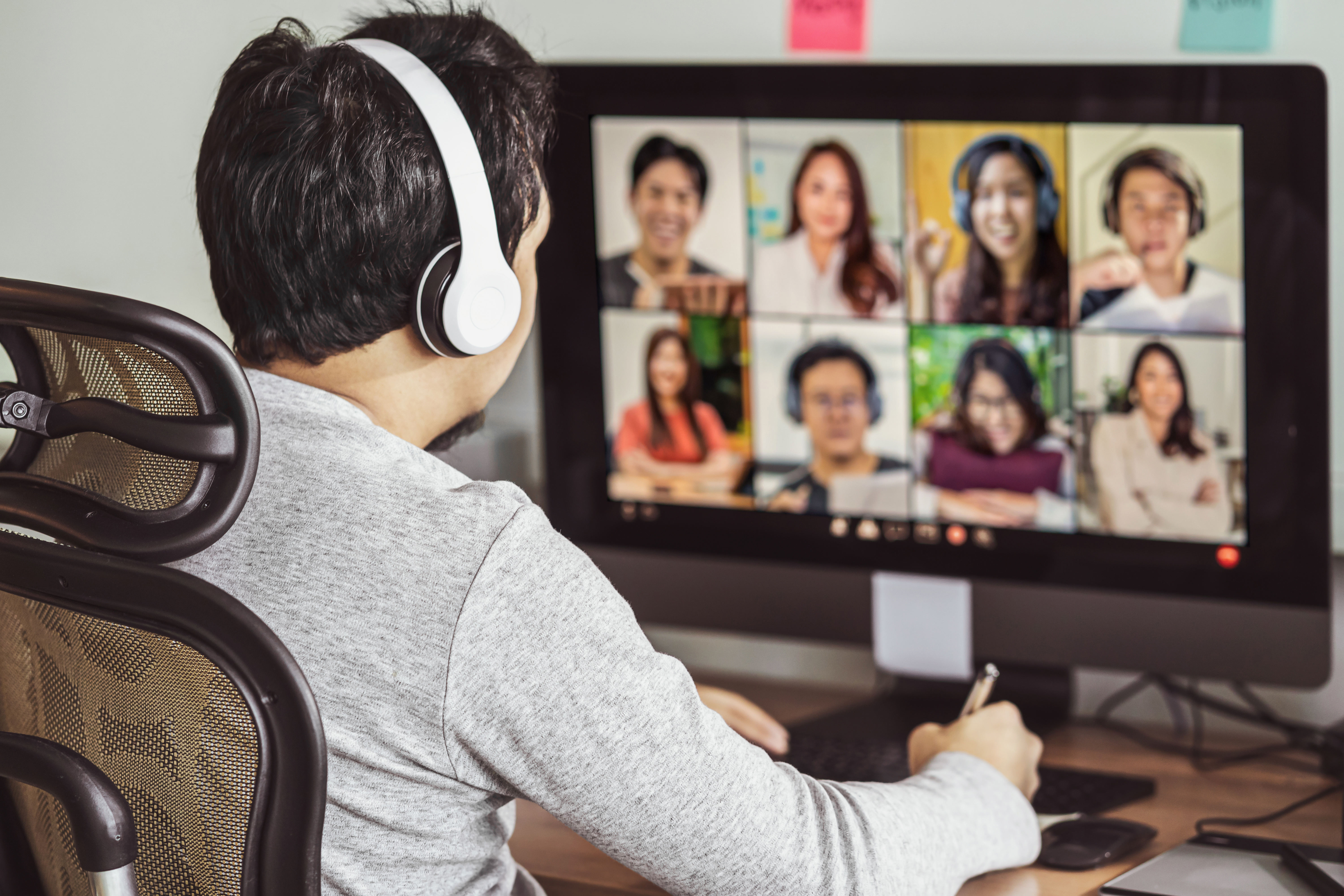Rear view of Asian man working and online meeting via video conference with colleague and team building when Covid-19 pandemic, Coronavirus outbreak, education and Social distancing,new normal concept Sistemas de Evaluación - Curso en Inmunización frente al SARS-COV2